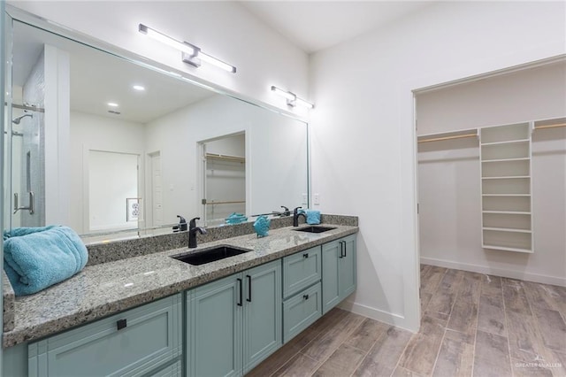 bathroom featuring hardwood / wood-style floors, vanity, and a shower with shower door