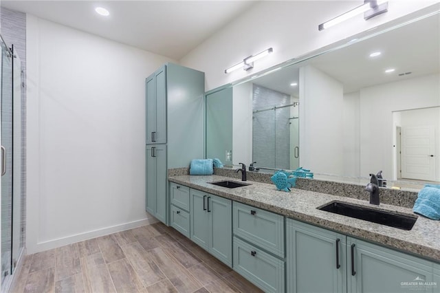 bathroom with vanity, hardwood / wood-style flooring, and a shower with shower door