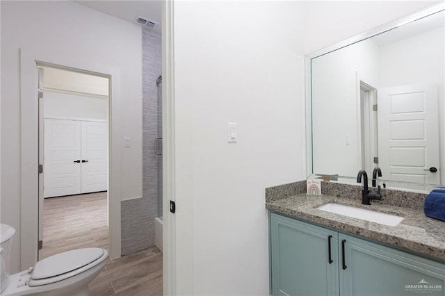 bathroom with hardwood / wood-style floors, vanity, and toilet