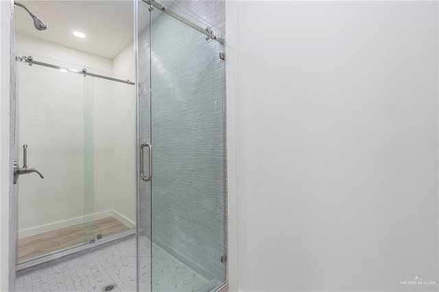 bathroom with hardwood / wood-style floors and an enclosed shower