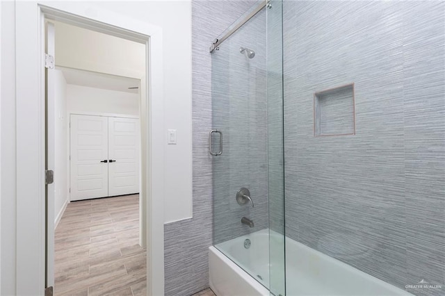 bathroom with shower / bath combination with glass door