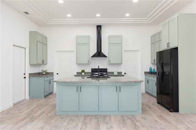 kitchen featuring a center island with sink, light hardwood / wood-style flooring, and black appliances