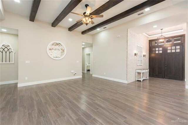 unfurnished living room featuring beamed ceiling, dark hardwood / wood-style flooring, and ceiling fan