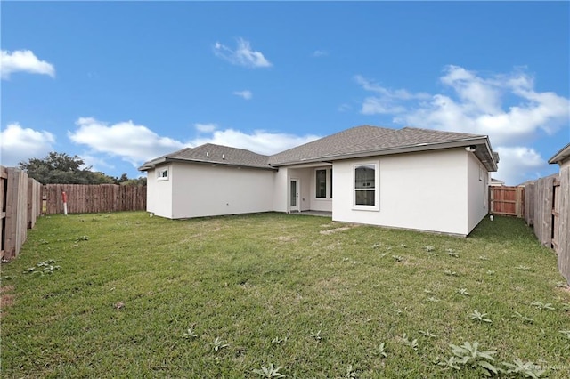 back of property featuring a fenced backyard, stucco siding, and a yard