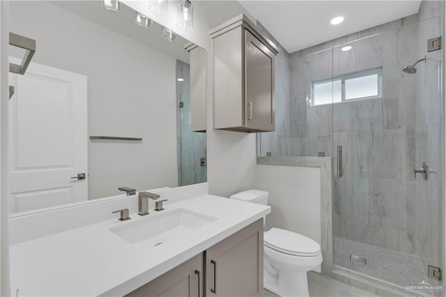 bathroom with recessed lighting, a marble finish shower, vanity, and toilet