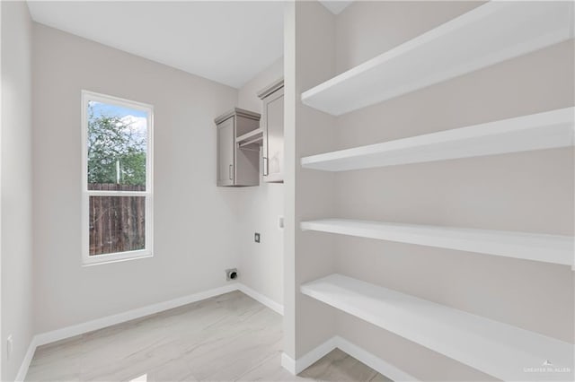 clothes washing area with laundry area, baseboards, and hookup for an electric dryer