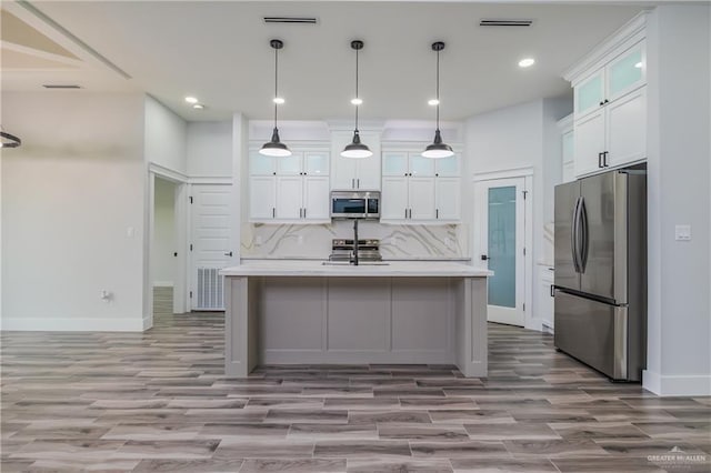 2316 Piedra St, Edinburg, TX 78542 - kitchen featuring stainless steel appliances, light countertops, baseboards, wood finished floors, and tasteful backsplash