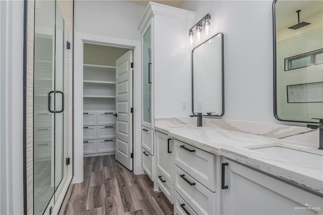 2316 Piedra St, Edinburg, TX 78542 - full bathroom with a stall shower, double vanity, wood finished floors, and a walk in closet