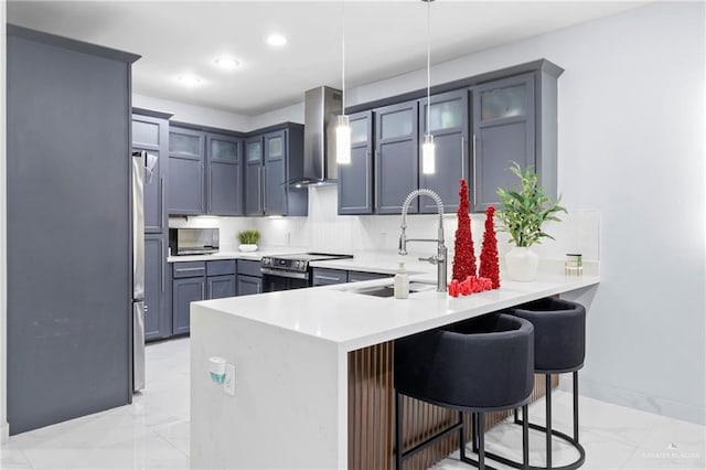 kitchen with kitchen peninsula, a breakfast bar, wall chimney exhaust hood, and stainless steel appliances