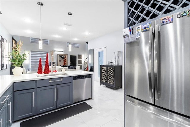 kitchen featuring pendant lighting, gray cabinetry, sink, and appliances with stainless steel finishes