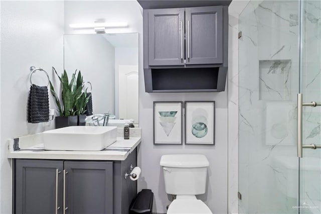 bathroom with vanity, toilet, and a shower with door