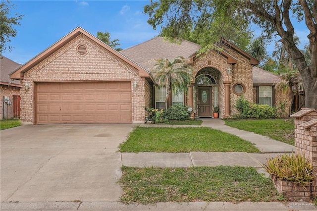 3704 San Gerardo St, Mission, TX 78572 - view of front of home with brick siding, a front lawn, concrete driveway, and a garage