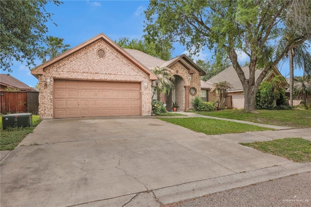 3704 San Gerardo St, Mission, TX 78572 - view of front facade featuring concrete driveway, a front lawn, fence, a garage, and brick siding