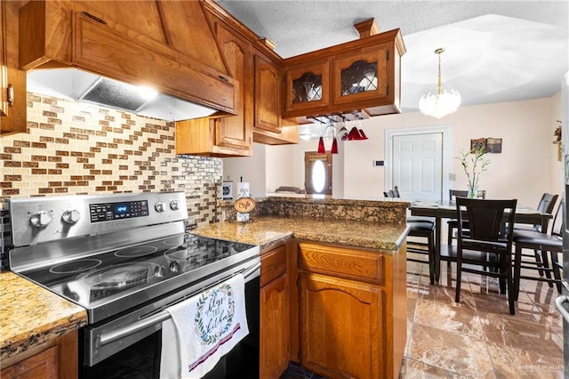 kitchen featuring stainless steel electric range oven, premium range hood, pendant lighting, tasteful backsplash, and kitchen peninsula