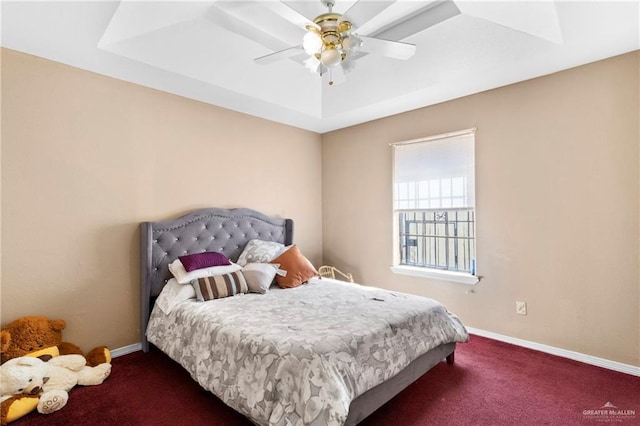 bedroom with a tray ceiling, ceiling fan, and dark colored carpet