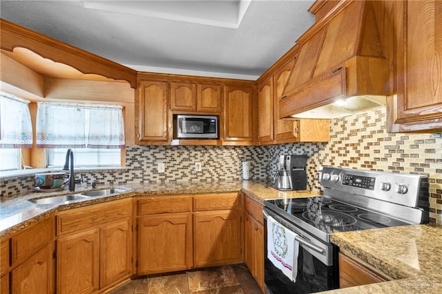 kitchen with appliances with stainless steel finishes, sink, backsplash, and light stone counters