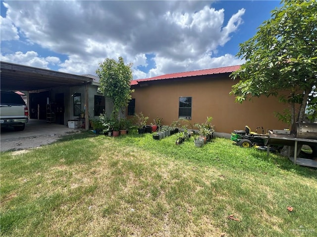 exterior space with a lawn and a carport