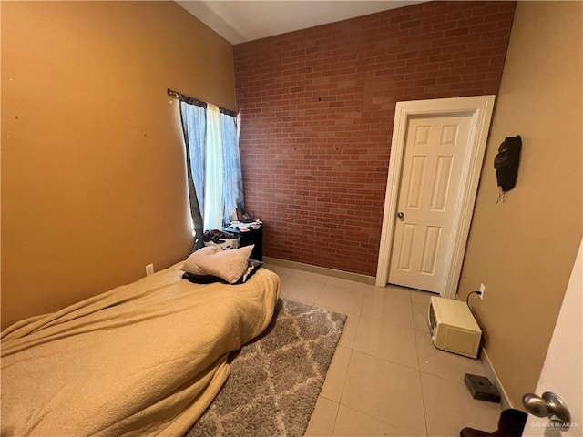 bedroom with light tile patterned floors and brick wall