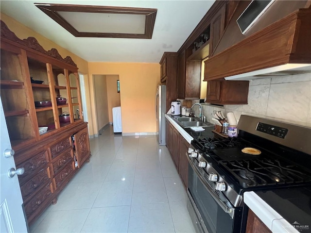 kitchen with premium range hood, sink, light tile patterned floors, appliances with stainless steel finishes, and tasteful backsplash