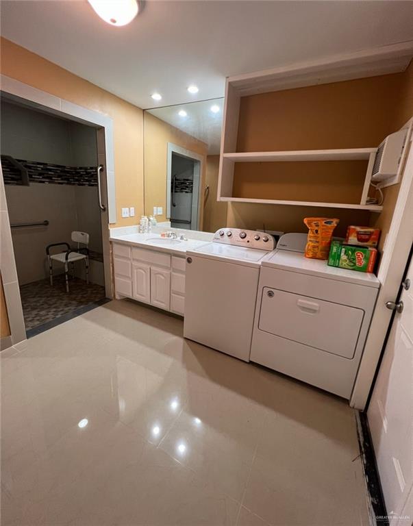 bathroom featuring tile patterned floors, vanity, and separate washer and dryer