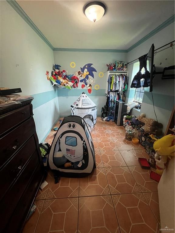 bedroom featuring tile patterned floors and ornamental molding