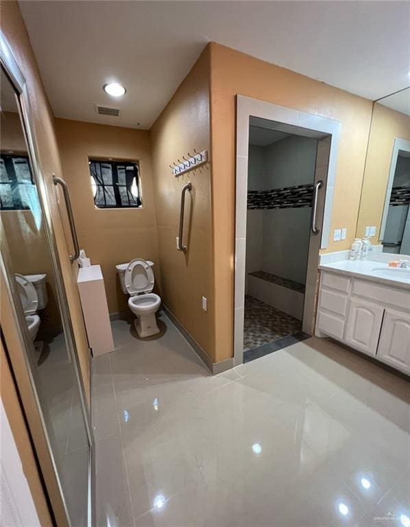 bathroom with a shower, tile patterned floors, vanity, and toilet