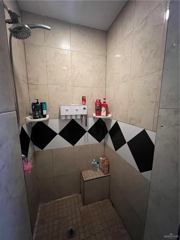 bathroom with walk in shower and tile walls