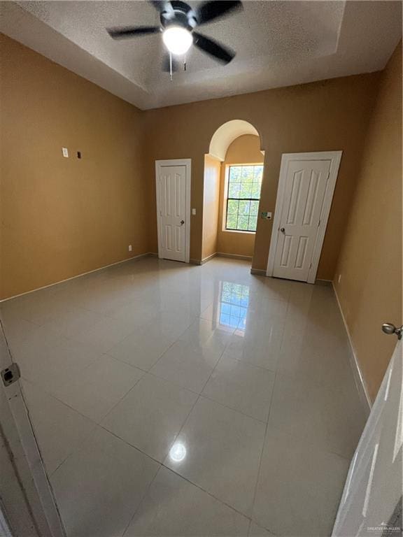 spare room featuring light tile patterned floors, a textured ceiling, and ceiling fan