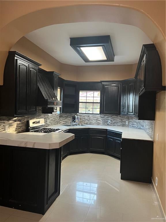 kitchen with decorative backsplash, stainless steel electric range oven, and sink