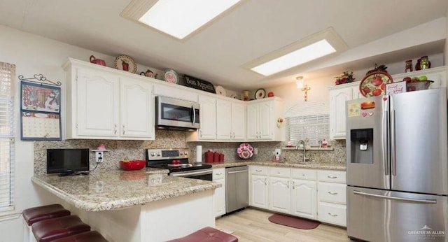 kitchen featuring white cabinetry, appliances with stainless steel finishes, and kitchen peninsula