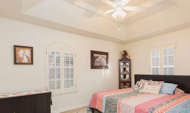 bedroom with a raised ceiling and ceiling fan