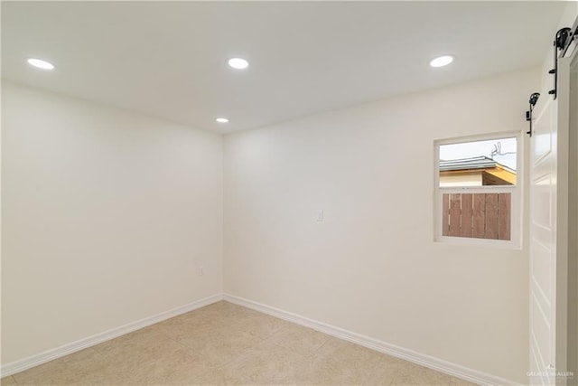 unfurnished room featuring a barn door