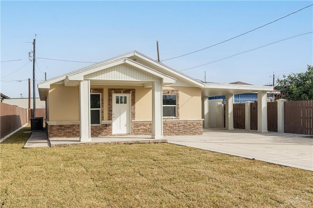 back of property with a yard, central AC, and a carport