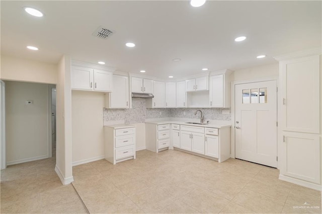 kitchen with tasteful backsplash, sink, and white cabinets