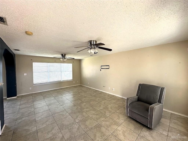 unfurnished room with tile patterned floors, baseboards, and a textured ceiling