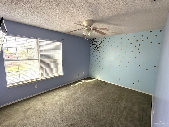 empty room featuring a ceiling fan, baseboards, a textured ceiling, and carpet flooring