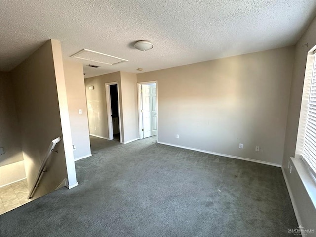 unfurnished room with baseboards, a textured ceiling, and dark carpet