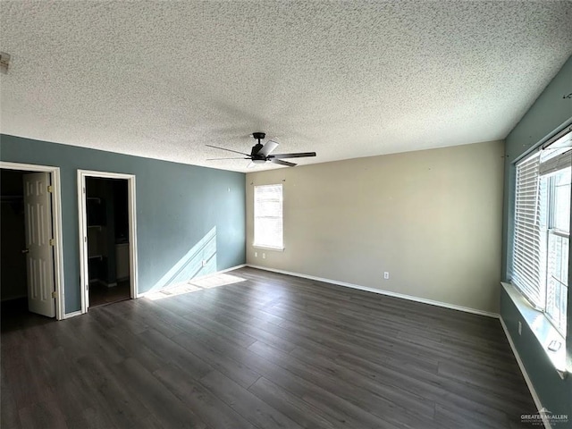 unfurnished bedroom with dark wood finished floors, ceiling fan, a textured ceiling, and baseboards