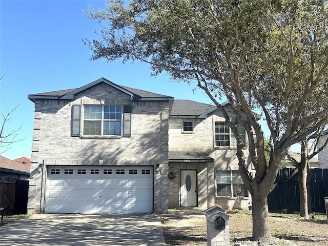 traditional-style home featuring a garage, brick siding, concrete driveway, and fence