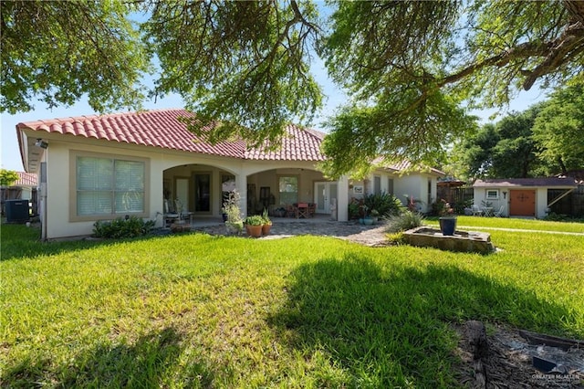 5512 Autumn Mist Ln, Brownsville, TX 78526 - back of property with a yard, stucco siding, an outdoor structure, a tile roof, and a patio area