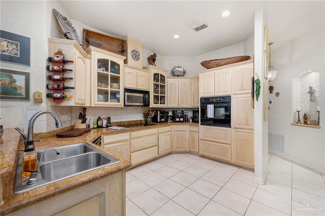 5512 Autumn Mist Ln, Brownsville, TX 78526 - kitchen with black appliances, light tile patterned floors, glass insert cabinets, light brown cabinets, and decorative backsplash