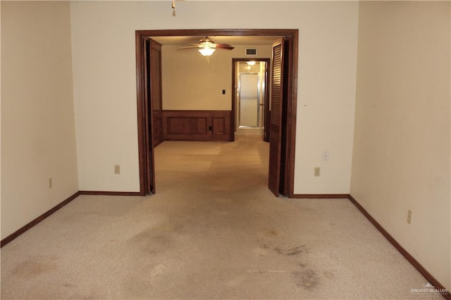 carpeted spare room featuring ceiling fan