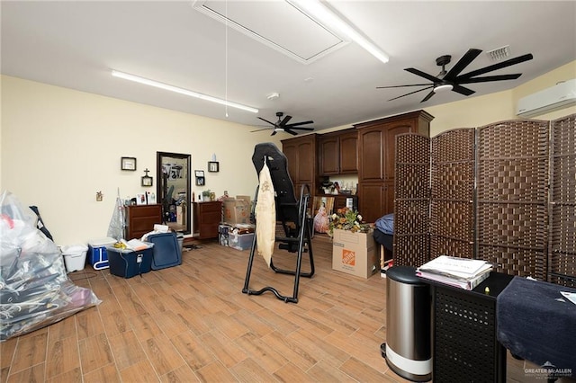 misc room featuring ceiling fan, a wall mounted AC, and light wood-type flooring