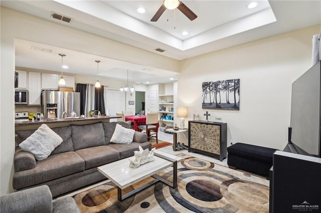 612 Valencia Ln, Brownsville, TX 78521 - living area featuring ceiling fan, recessed lighting, a tray ceiling, and a chandelier