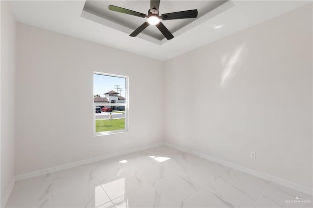 2203 San Charbel St, San Juan, TX 78589 - spare room with baseboards, a raised ceiling, marble finish floor, and ceiling fan