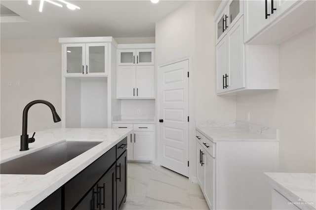 2203 San Charbel St, San Juan, TX 78589 - kitchen with a sink, dark cabinets, white cabinetry, light stone countertops, and marble finish floor