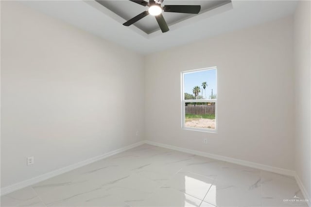 2203 San Charbel St, San Juan, TX 78589 - spare room with a tray ceiling, marble finish floor, baseboards, and a ceiling fan