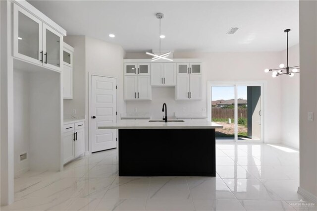 2203 San Charbel St, San Juan, TX 78589 - kitchen with marble finish floor, a kitchen island with sink, a sink, and an inviting chandelier