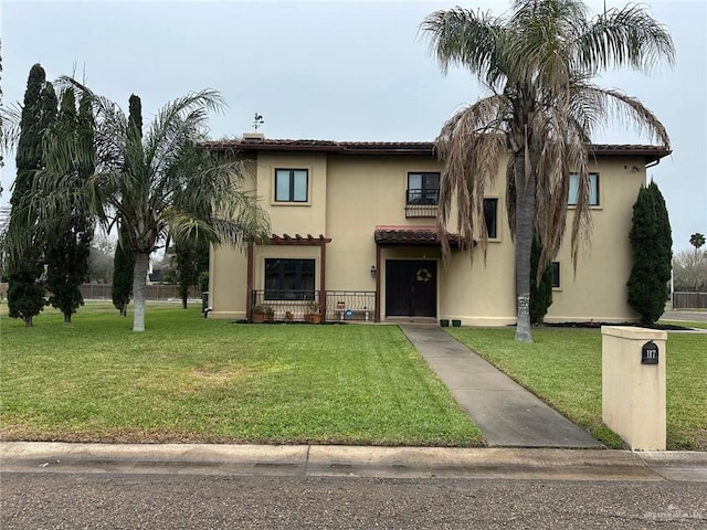 mediterranean / spanish-style home with a front lawn and stucco siding