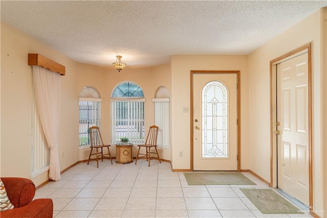 1717 Sun St, Mission, TX 78572 - entryway with light tile patterned floors, a textured ceiling, and baseboards